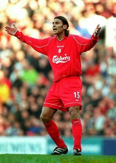 a soccer player is standing on the field with his arms out and one hand outstretched