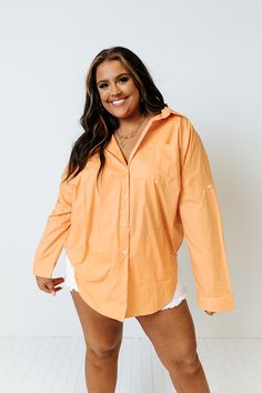 Channel all the good luck on your special day with this casual cute orange plus size top featuring lightweight material, a button up front with a collared neckline, long loose sleeves with roll tab cuffs, a single accent chest pocket, and a relaxed silhouette that falls into a rounded hemline!   Measurements 1XL variant has  a Bust of 58",  a Hip of 54",  a Length of 35",  a Sleeve Length of 15",  a Waist of 53".  2XL variant has  a Bust of 60",  a Hip of 55",  a Length of 36",  a Sleeve Length Trendy Collared Orange Shirt, Trendy Orange Collared Shirt, Oversized Long Sleeve Orange Blouse, Oversized Orange Long Sleeve Blouse, Oversized Orange Long Sleeve Shirt, Trendy Orange Long Sleeve Shirt, Oversized Orange Shirt With Long Sleeves, Orange Collared Blouse For Spring, Orange Relaxed Fit Blouse For Day Out