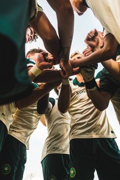 a group of men standing around each other in a huddle