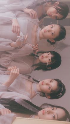 three young women standing next to each other in front of a mirror with their hands together