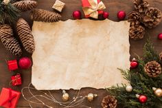 an old paper surrounded by christmas decorations and pine cones