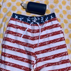 Red, White, And Blue Striped Draw String Waist Comfortable Casual Beach Shorts With Flag Print, White Beach Bottoms For 4th Of July, White Bottoms For 4th Of July Beach Outing, Casual Shorts For 4th Of July Beach, Casual Beach Shorts For 4th Of July, Patriotic Beach Shorts With American Flag Print, Casual Beach Bottoms With Flag Print, Casual Flag Print Bottoms For Beach, Casual Bottoms With Flag Print For Beach