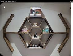 the shelves are made out of wood and have various items on them in hexagonal shapes