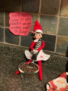 an elf is sitting on top of a bowl with chocolate chips in front of him