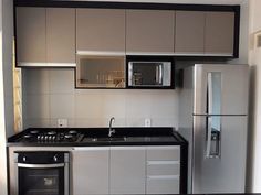 an empty kitchen with stainless steel appliances and black counter tops, along with white walls