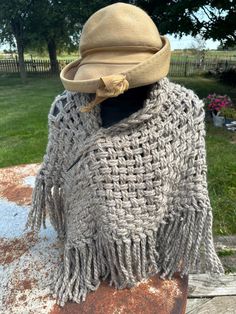 Dress it up or dress it down. Wear to a wedding or wear with jeans. This shawl was woven on a triangle loom using continuous strand weaving. 56" tip to tip. 28" high. Fringe adds 7". Vintage hat sold separately. The yarn is 20% alpaca 80% acrylic. Taupe  Wrap yourself in the cozy luxury of our hand-woven alpaca shawl, a testament to craftsmanship and comfort. Meticulously created with chunky alpaca yarn, this shawl offers both warmth and texture, making it a perfect companion for chilly days and stylish evenings. The chunky yarn adds a delightful depth to the shawl, providing a plush feel that's as comforting as it is fashionable. Adorned with nice thick fringe, this accessory not only adds a touch of flair but also enhances the overall richness of the design. Elevate your winter wardrobe Beige Fringed Poncho Shawl, Beige Fringe Shawl Poncho, Bohemian Weaving Shawl For Fall, Bohemian Fall Shawl With Weaving, Triangle Loom, Thick Fringe, Alpaca Shawl, Cozy Luxury, Alpaca Yarn