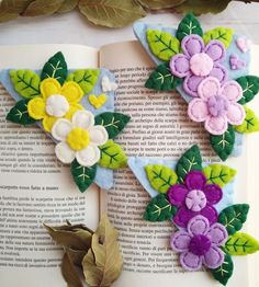 an open book with flowers and leaves on it