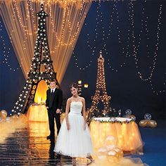 a bride and groom standing in front of the eiffel tower at their wedding