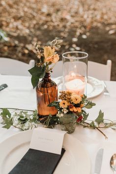 the table is set with flowers and candles