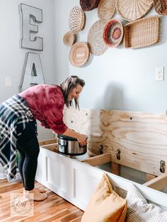 a woman is holding a pot in the kitchen