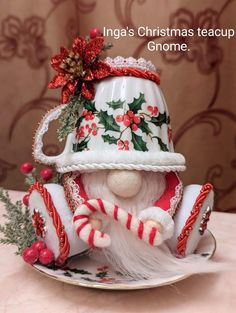 a santa clause figurine sitting on top of a plate with candy canes