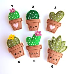 four felt cactus plant magnets with faces and hearts on them, sitting next to each other