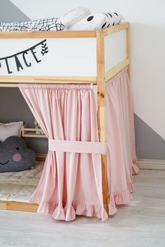 a bunk bed with pink curtains and pillows