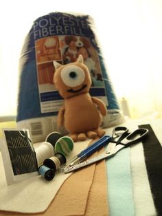 a stuffed animal sitting on top of a table next to sewing supplies