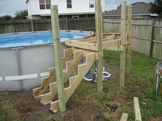 an above ground swimming pool with steps leading up to the deck and above ground hot tub