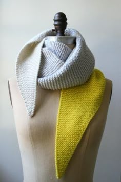 a white and yellow scarf on top of a mannequin