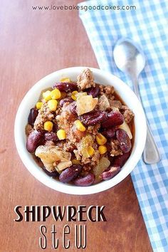 a bowl filled with beans and corn on top of a wooden table