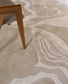 a chair sitting on top of a wooden floor next to a rug covered in swirls