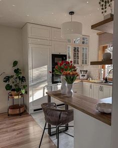 a kitchen filled with lots of white cabinets and counter top space next to a dining room table