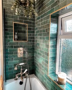 a bath tub sitting under a window next to a sink and shower faucet