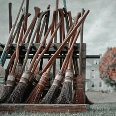 a pile of brooms sitting next to each other on top of a wooden crate