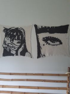 two decorative pillows hanging on the wall next to a bed with bamboo headboard and foot board