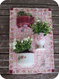 two vases with flowers on a pink and white table cloth