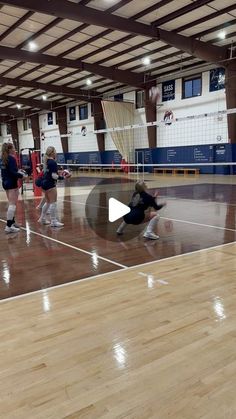 some girls are playing volleyball in a gym