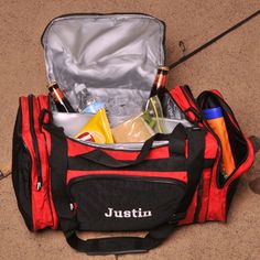 an open red duffel bag filled with bottles and other personal care items in it