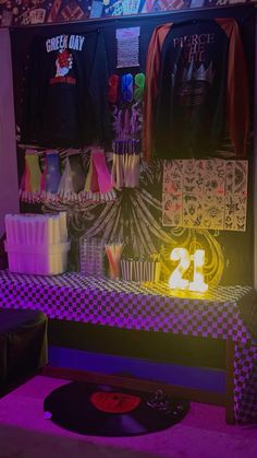 a room filled with lots of different types of clothing on display in front of a neon sign