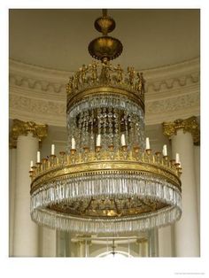 a large chandelier hanging from the ceiling in a room with columns and pillars