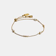 Brilliant crystals add a hint of sparkle to this delicate bracelet featuring perfectly placed crystal pearls. Finished with a sliding bead closure that adjusts to most wrists it's detailed with our Signature charm and diminutive hangtag for an iconic touch. | Coach Classic Crystal Pearl Slider Bracelet - Women's - Gold Felt Pouch, Slider Bracelet, Gold Bracelet For Women, Monogrammed Items, Crystal Pearls, Women Accessories Jewelry, Belt Size, Delicate Bracelet, Womens Jewelry Bracelets