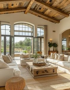 a living room filled with lots of furniture and large windows in front of the doors