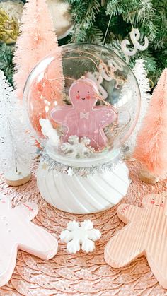 a snow globe with gingerbread man in the center surrounded by christmas trees and cookies