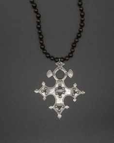 This unique pendant captures the essence of the traditional Tuareg design. Nomads of the desert, the Tuareg inhabit a vast territory spanning from the Moroccan Saharan desert to Burkina Faso in the south. This silver Nigerian Tuareg Bartchakea cross is paired with a hand-knotted shungite and garnet chain. The shungite & garnet chain is 73 cm long [28.75 in long] Traditional Cross Necklace With Large Pendant, Traditional Cross Pendant Large Jewelry, Traditional Necklace With Large Cross Pendant, Traditional Cross Pendant Necklace With Large Pendant, Traditional Cross Pendant For Ceremonial Occasions, Unique Pendant, The Desert, Healing Stones, The South