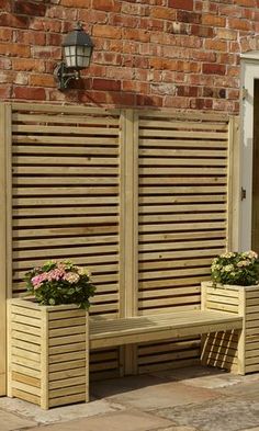 two wooden planters sitting on top of a bench next to a brick building with white doors