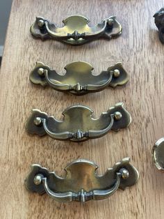 four metal handles on a wooden surface