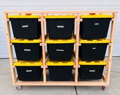 several black and yellow bins are stacked on a cart