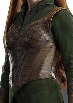 a woman with long red hair wearing a green outfit