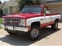 a red and white truck parked in front of a house