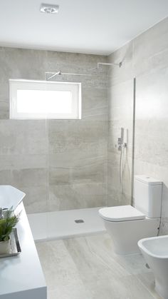 a bathroom with a toilet, sink and bathtub next to each other in front of a window