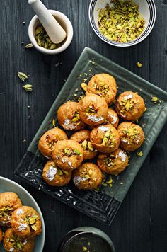 there are many small muffins on the table next to bowls and spoons