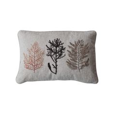 an embroidered pillow with three different types of leaves on the front and back of it