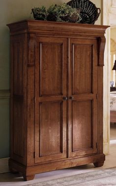 a wooden armoire sitting on top of a carpeted floor