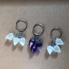 three key chains with charms attached to them