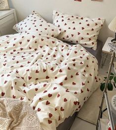 an unmade bed with red hearts on it