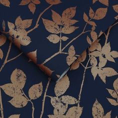 a blue and gold wallpaper with leaves on it, including one leaf that has been cut in half