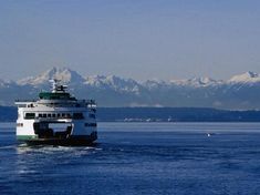 a large boat is sailing in the water with mountains in the backgrouds