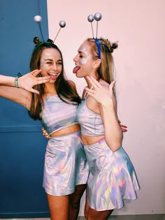 two young women dressed in silver posing for the camera