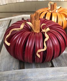 two decorative pumpkins sitting on top of a wooden table next to eachother